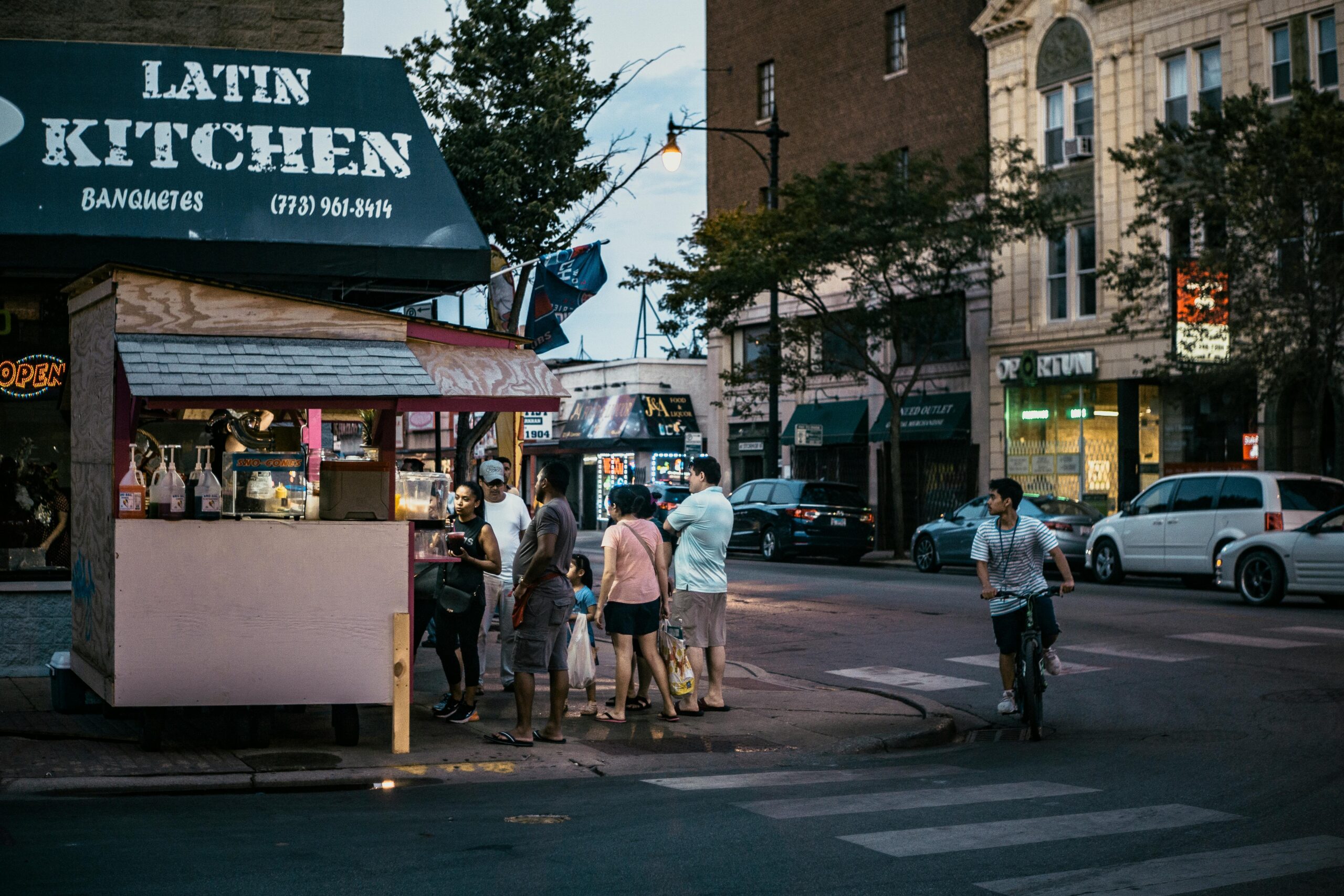 People gather at a street food stand under city lights in Chicago, capturing a lively urban evening vibe.